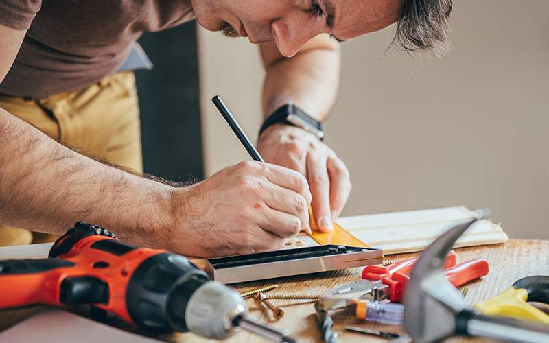 Builder measuring some wood